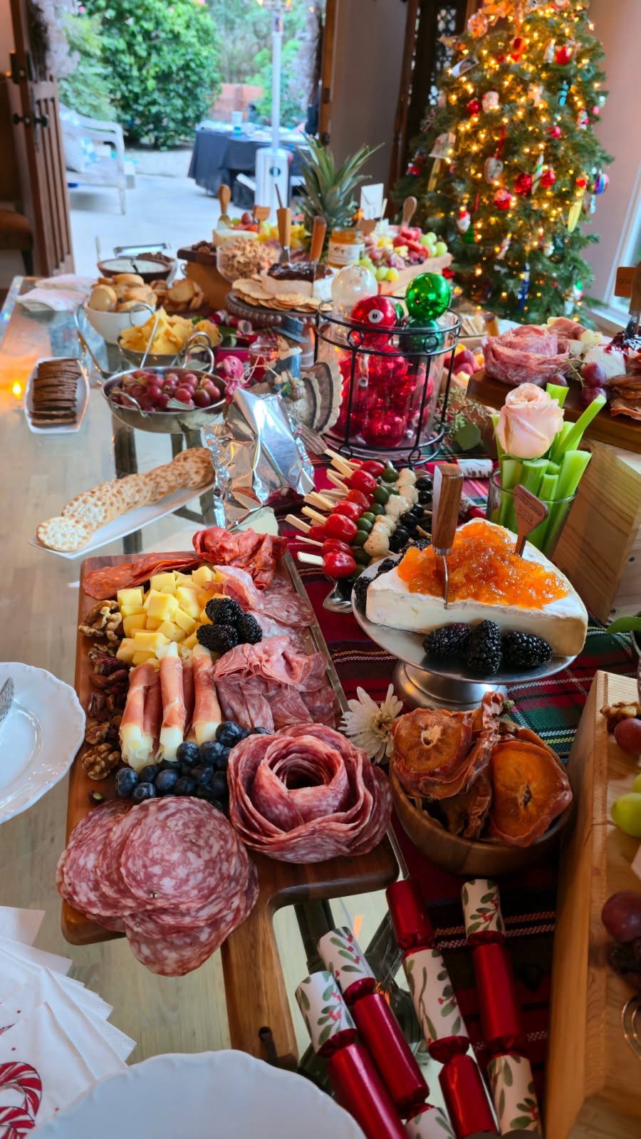 Holiday grazing table with charcuterie beside a Christmas tree
