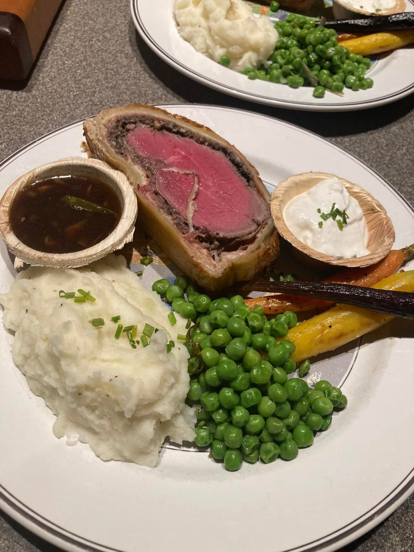 Beef Wellington slice with mashed potatoes, peas and glazed carrots