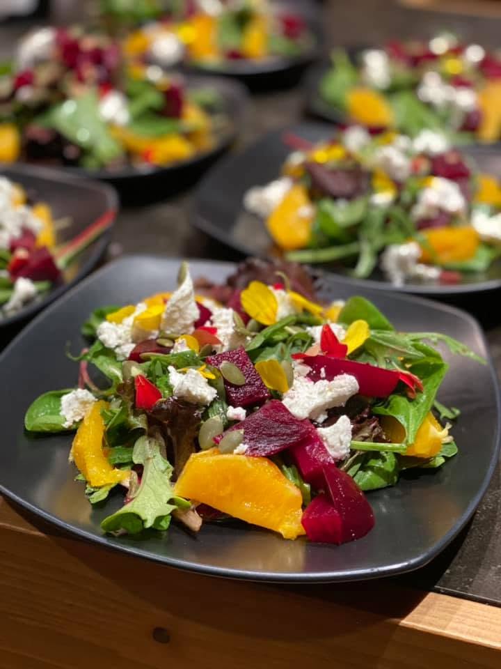 Plated beet, orange and goat cheese salad with edible flowers