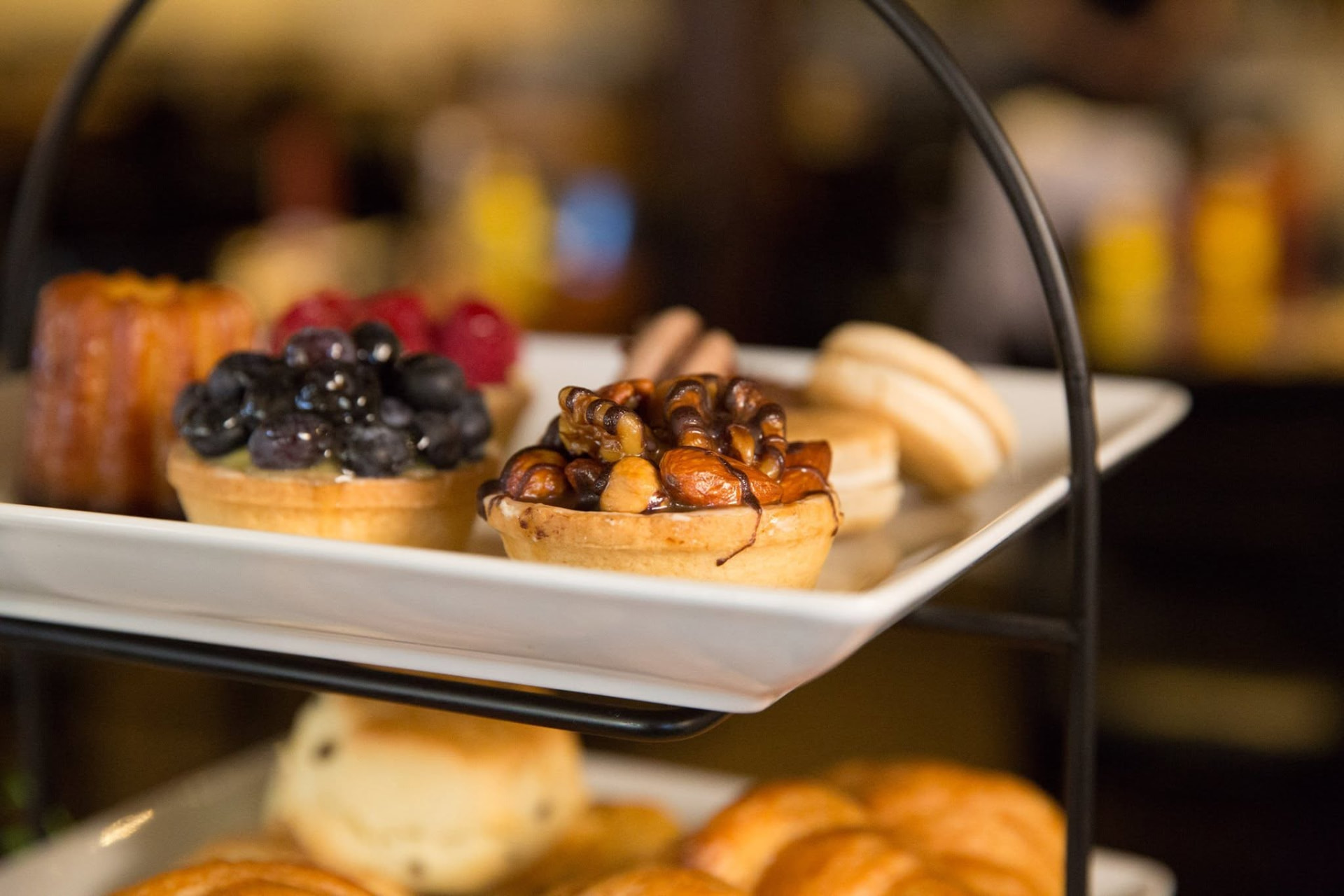 Tiered stand of tarts, macarons and scones